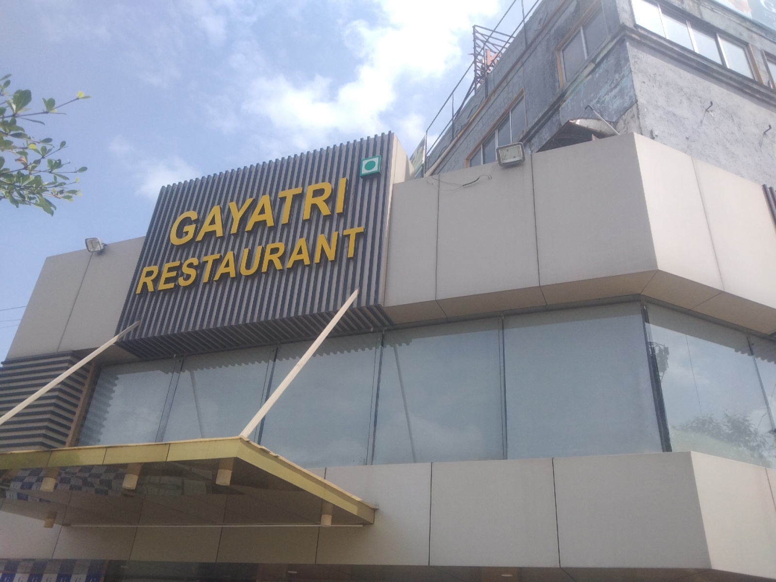 Gayatri Restaurant illuminated night facade in Vatva GIDC, Ahmedabad, with warm golden signage